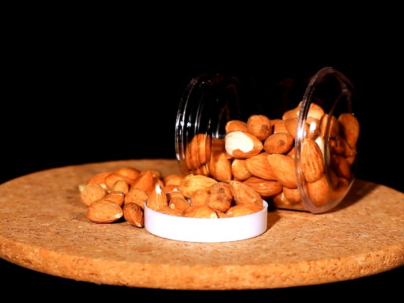 prikaz badema na pluti od drveta prosutih iz teglice