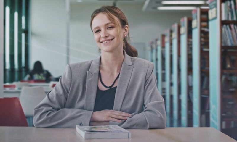 devojka sedi u kancelariji u sivom sakou